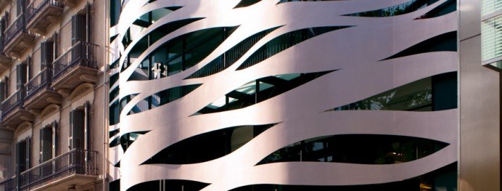 Un edificio con una fachada metálica ondulada capturado en una impresionante sesión de fotos arquitectónica.