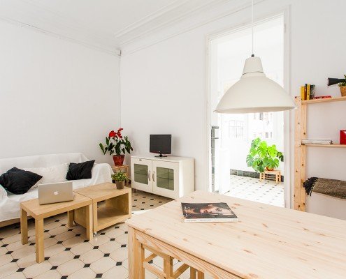 Una pequeña sala de estar con mesa y sillas, bellamente captada por un fotógrafo de interiores.