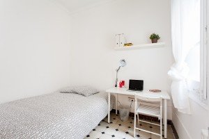 Un dormitorio pequeño con una cama y un escritorio, perfecto para un retiro acogedor o un espacio de trabajo productivo.