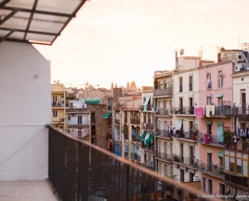 Un fotógrafo que captura la belleza arquitectónica de una ciudad al atardecer desde un pintoresco balcón.