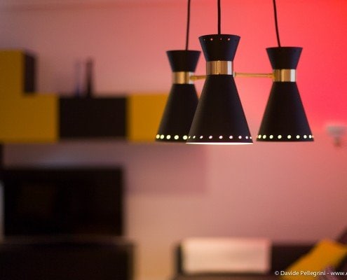 Una lámpara colgante negra y amarilla en un salón.