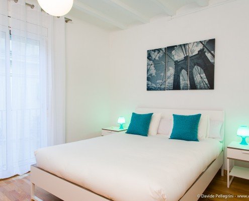 Una cama blanca en un dormitorio para un reportaje fotográfico.