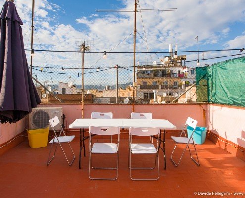 Una azotea en barcelona con una mesa y sillas, capturada en una fascinante fotografía arquitectónica.
