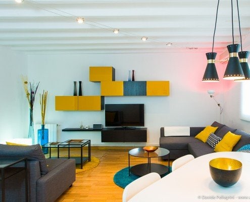 Una amplia sala de estar con un diseño contemporáneo con un elegante sofá y un gran televisor de pantalla plana.