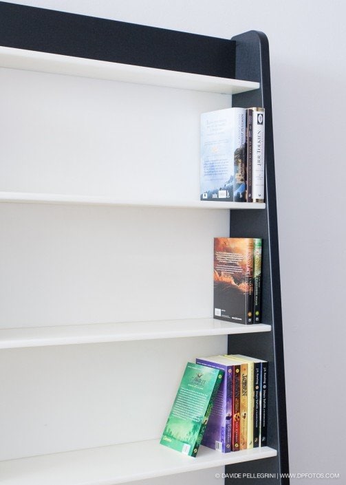Una estantería en blanco y negro con libros, capturada a través de fotografías arquitectónicas.