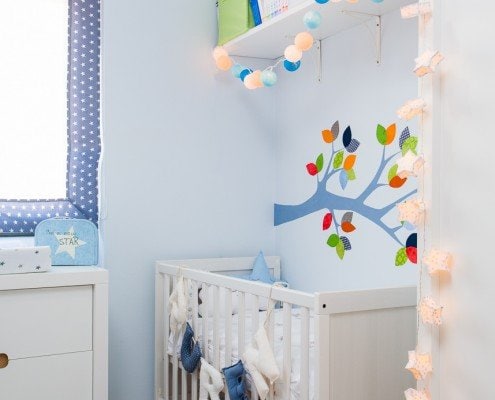 Una cuna blanca en la habitación de un bebé capturada por un talentoso fotógrafo de interiores.