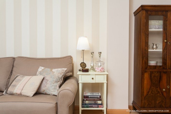 Un sofá beige en una sala de estar, capturado a través de una sesión de fotografía arquitectónica.