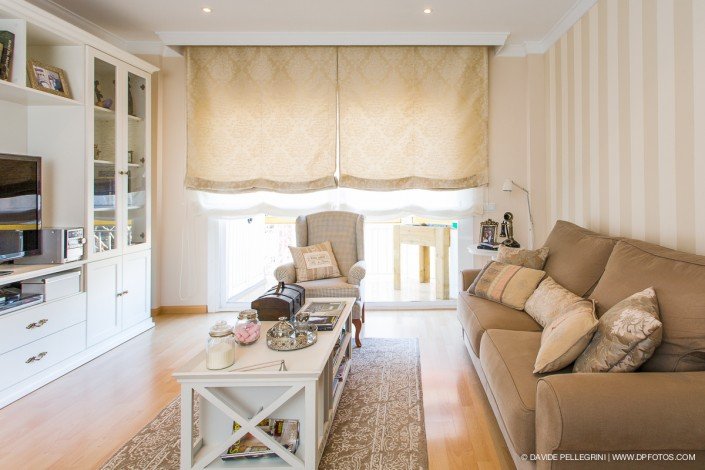 Una sala de estar con un sofá color canela y un televisor, bellamente capturada por un fotógrafo de arquitectura especializado en fotografía de arquitectura de interiores.