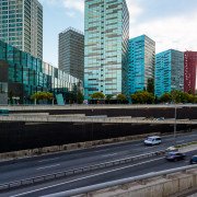 Una imagen borrosa de automóviles circulando por una autopista en una ciudad, capturada por un talentoso fotógrafo de arquitectura.