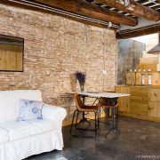 Una acogedora sala de estar adornada con un elegante sofá blanco y una mesa de madera elegantemente elaborada.