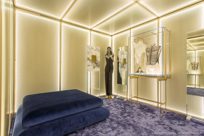 Descripción: Una sala con un maniquí y una alfombra azul en una tienda de lujo.