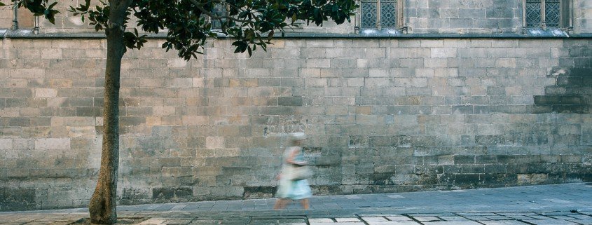 Una mujer camina por una calle adoquinada como parte de un reportaje fotográfico.