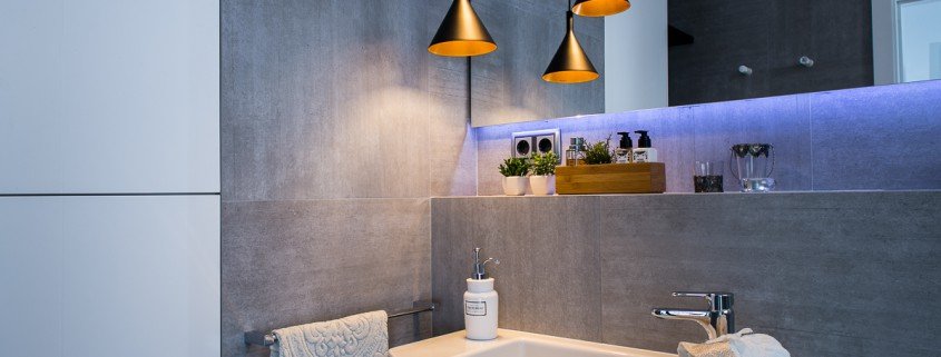 Un baño con lavabo y lámpara, perfecto para fotografía de interiores.