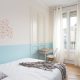 Descripción: Una habitación con paredes azules y blancas y una cama blanca en estilo nórdico.