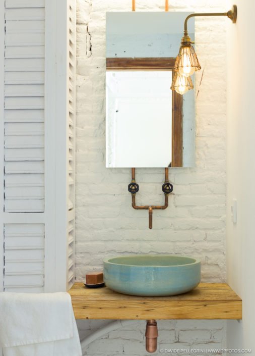 Una fotografía de la reforma de una oficina en Barcelona, mostrando un baño con un lavabo y un espejo.