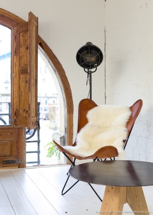 Una silla en una habitación con una mesa y un ventilador, captada en una llamativa fotografía.