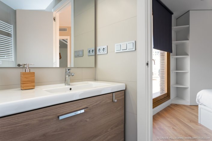 Un baño con lavabo y espejo, perfecto para fotografía de arquitectura e interiores.