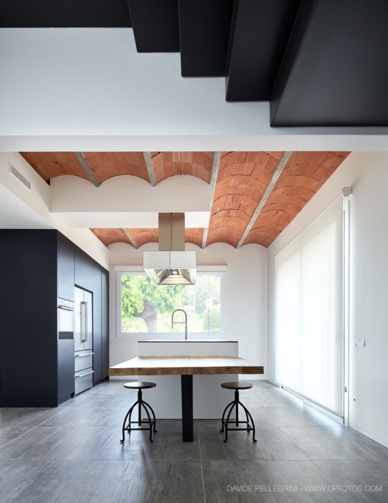 Una cocina moderna con techo vigas catalanas en una vivienda unifamiliar.