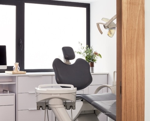 Descripción: Un consultorio dental con una silla de dentista y una ventana.