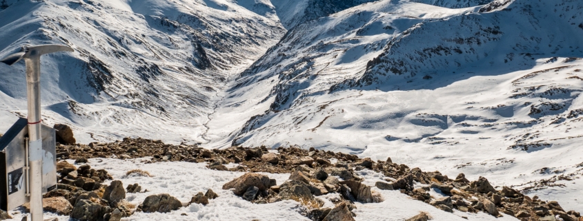 Una montaña cubierta de nieve con un cartel encima. Perfecta para una fotografía o para capturar la impresionante belleza de la naturaleza, esta montaña muestra tanto la grandeza de la arquitectura como la nítida