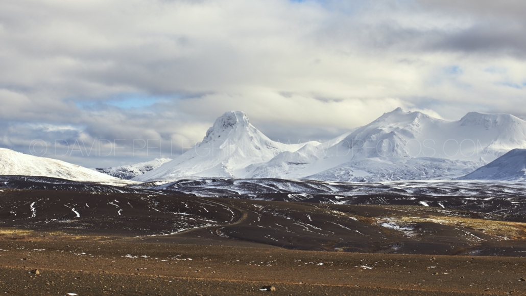Una cadena montañosa nevada en la distancia capturada por un talentoso fotógrafo de paisajes.
