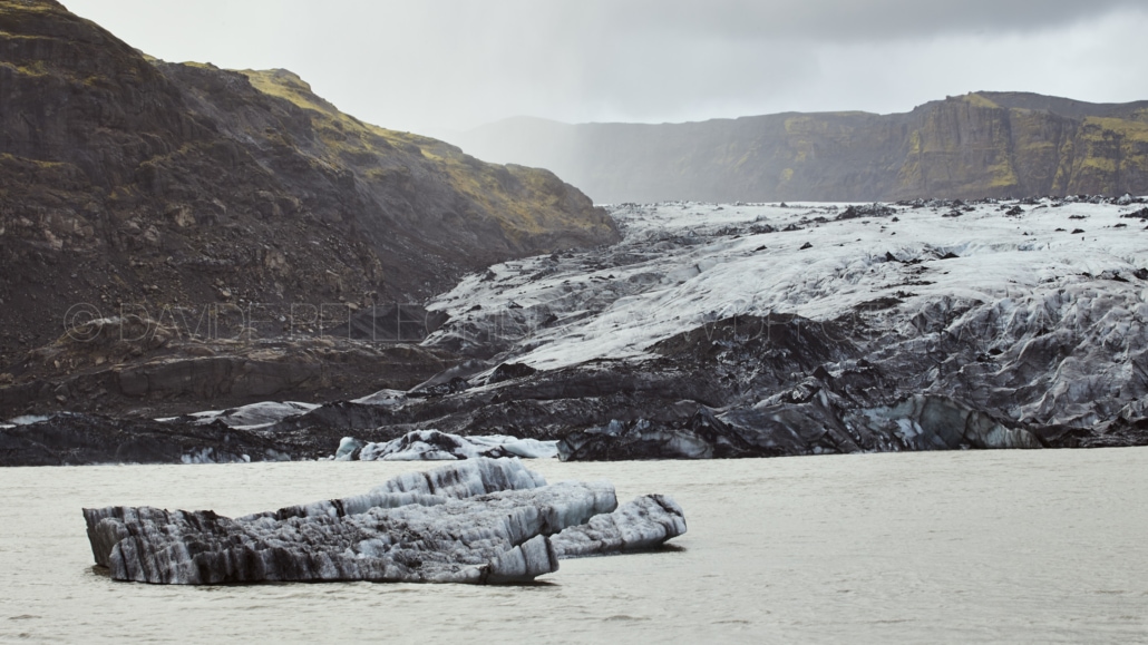 Un glaciar con icebergs flotando en el agua, captado por un talentoso fotógrafo experto en fotografía arquitectónica y de interiores.