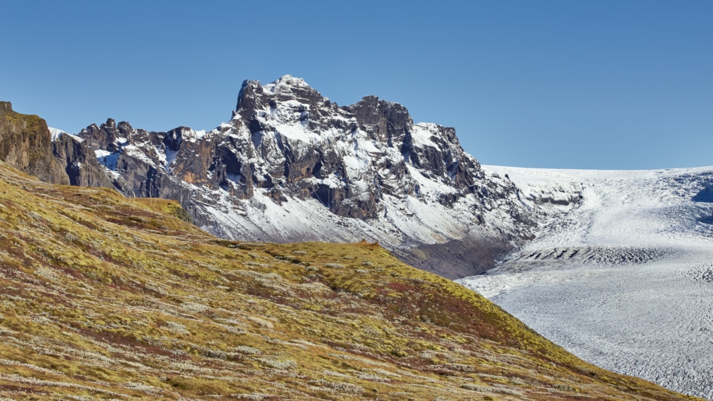 Una cadena montañosa con un glaciar al fondo capturada por un talentoso fotógrafo de paisajes.
