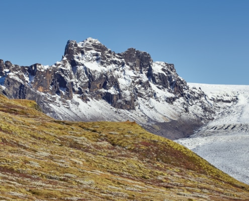 Una cadena montañosa con un glaciar al fondo capturada por un talentoso fotógrafo de paisajes.