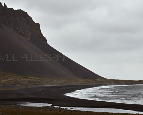 Playa de arena negra en Islandia, bellamente capturada por un talentoso fotógrafo de arquitectura.