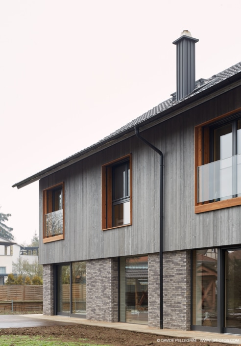 Una casa moderna con revestimiento de madera y ventanas.