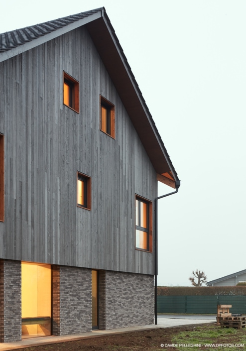 Una casa moderna con revestimientos y ventanas de madera, conocida como La Casa Gris.