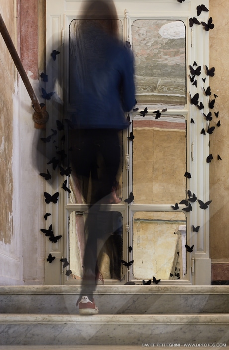 Una mujer baja unas escaleras en un entorno arquitectónico impresionante, capturado en un sorprendente reportaje fotográfico de interiores.