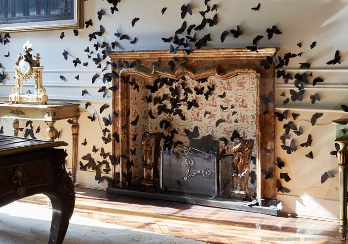 Una sala de interiorismo con chimenea revestida de murciélagos negros.