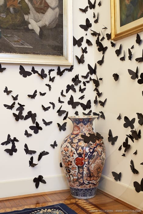 Una habitación visualmente impresionante con una gran cantidad de mariposas adornando las paredes, perfecta para interiorismo o un fascinante proyecto de arquitectura. Capture la belleza de este espacio a través de un encantador