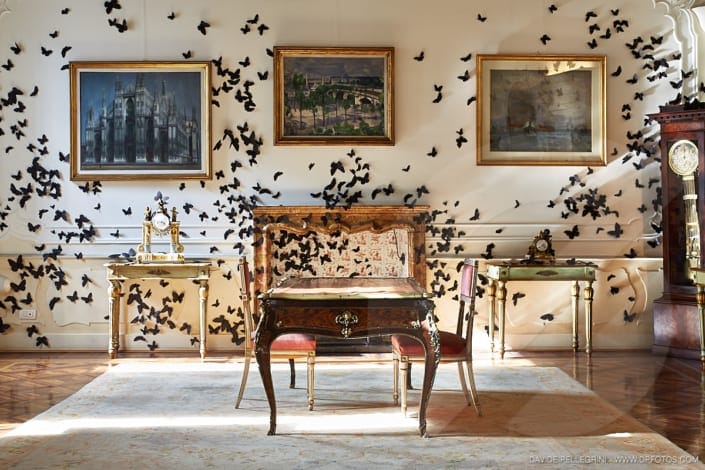 Una habitación con muchas mariposas negras en la pared, perfecta para interiorismo o para capturar imágenes impresionantes para un reportaje fotográfico. La combinación de mariposas de colores oscuros contra las paredes añade