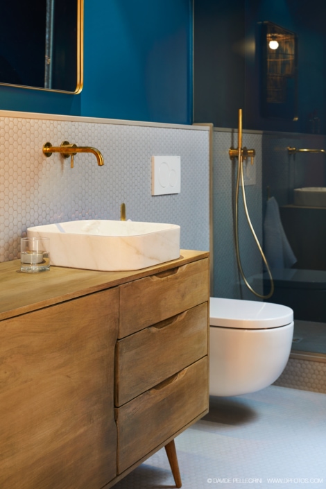 Descripción: Un baño con paredes azules y un mueble de lavabo hecho de madera.
