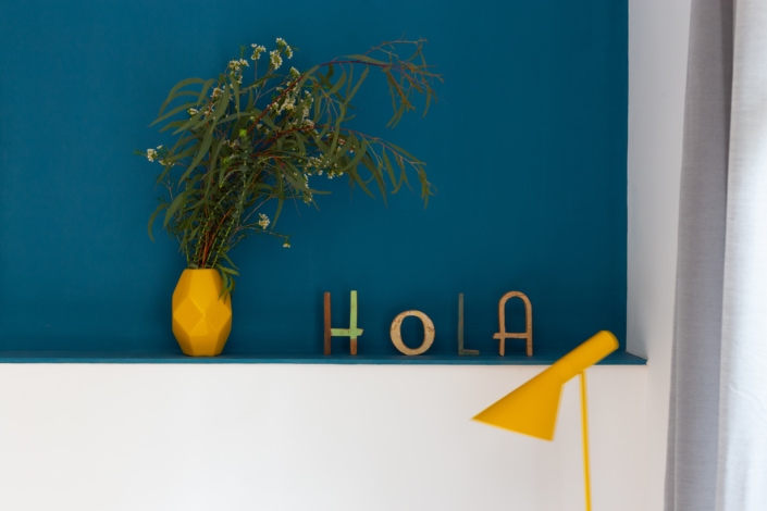 Una pared azul con la palabra hola, perfecta para interiorismo o reportaje fotográfico de arquitectura.