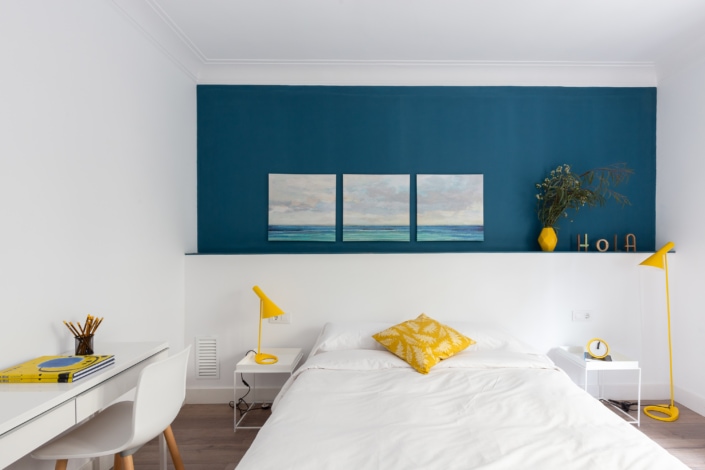 Descripción: Un dormitorio con paredes azules y acentos amarillos.