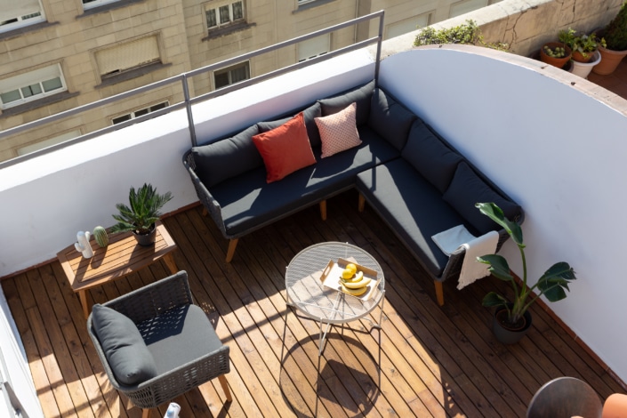 Un balcón con muebles, mesa y un toque de interiorismo.