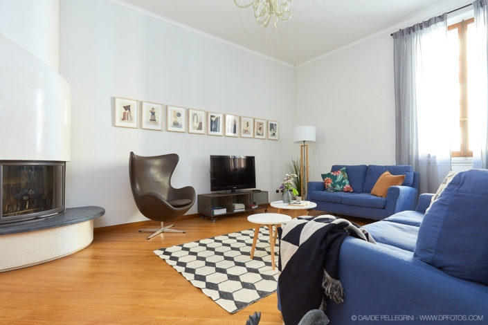Un reportaje de interiorismo en una sala de estar con un sofá azul y un televisor.