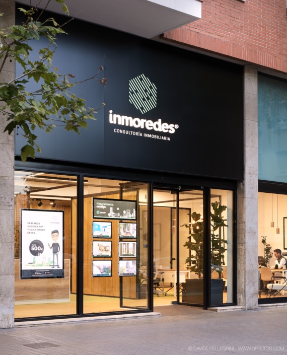 La entrada de un edificio de oficinas que presenta un letrero que muestra la palabra "imoders", que muestra una combinación de elementos de diseño arquitectónico e interiorismo.