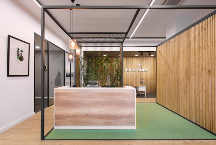 Un reportaje sobre un espacio de arquitectura e interiorismo con una alfombra verde y paredes de madera.