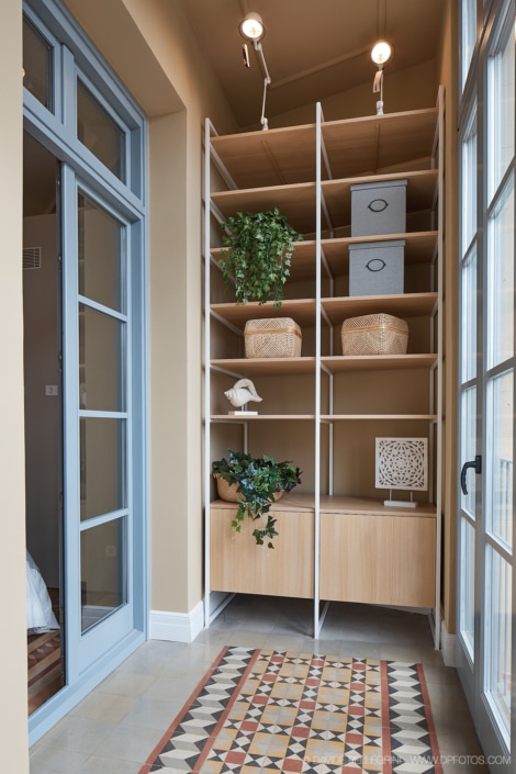 Un reportaje de un interiorismo con una arquitectura que incluye una estantería de madera y un suelo de azulejos.