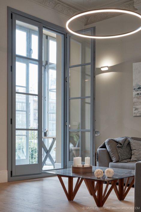 Una lámpara circular inspirada en la arquitectura realza el interiorismo de una sala de estar moderna en este elegante reportaje.