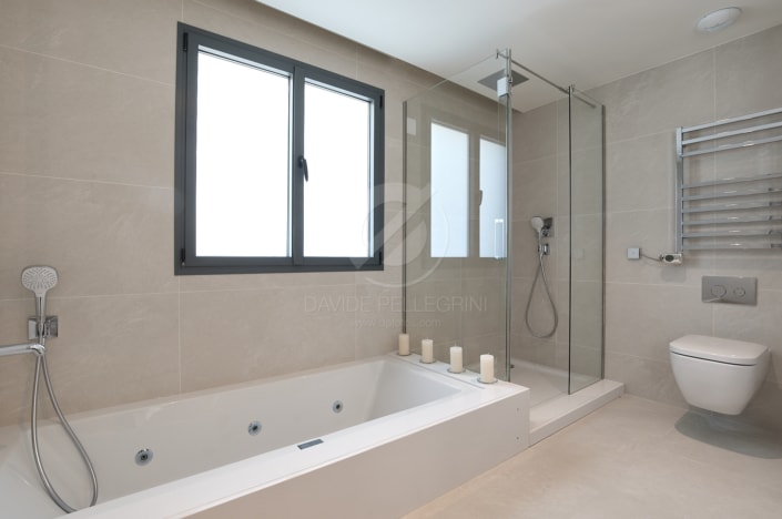 Un moderno baño de alto standing con ducha de vidrio e inodoro.