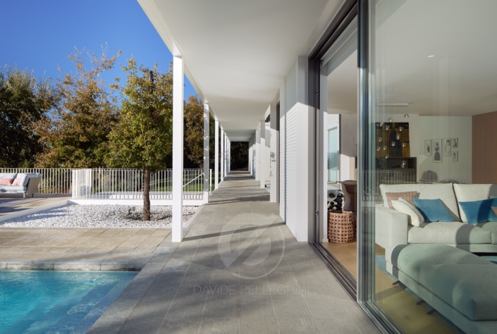 Una impresionante casa con puertas de cristal y una lujosa piscina. (arquitectónica)