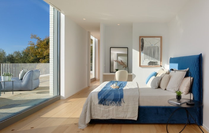 Un dormitorio con un gran ventanal perfecto para fotografía de interiores.