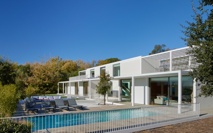 Una casa moderna con piscina y patio en una villa.