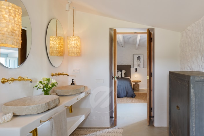 Un elegante baño con dos lavabos y un gran espejo, perfecto para capturar impresionantes fotografías de masías.