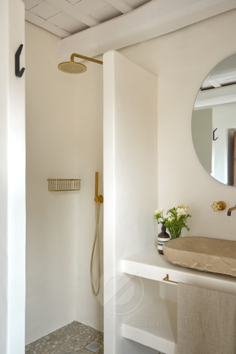 Un baño con lavabo blanco y espejo para una sesión fotográfica realizada por un fotógrafo de masías.